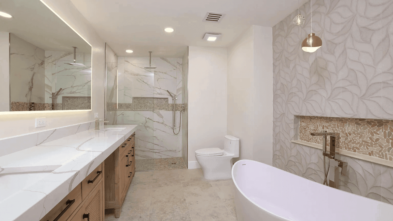 A primary bath finished in book-matched marble and brass fixtures.